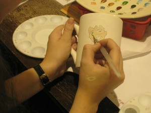 An attendee painting on ceramics